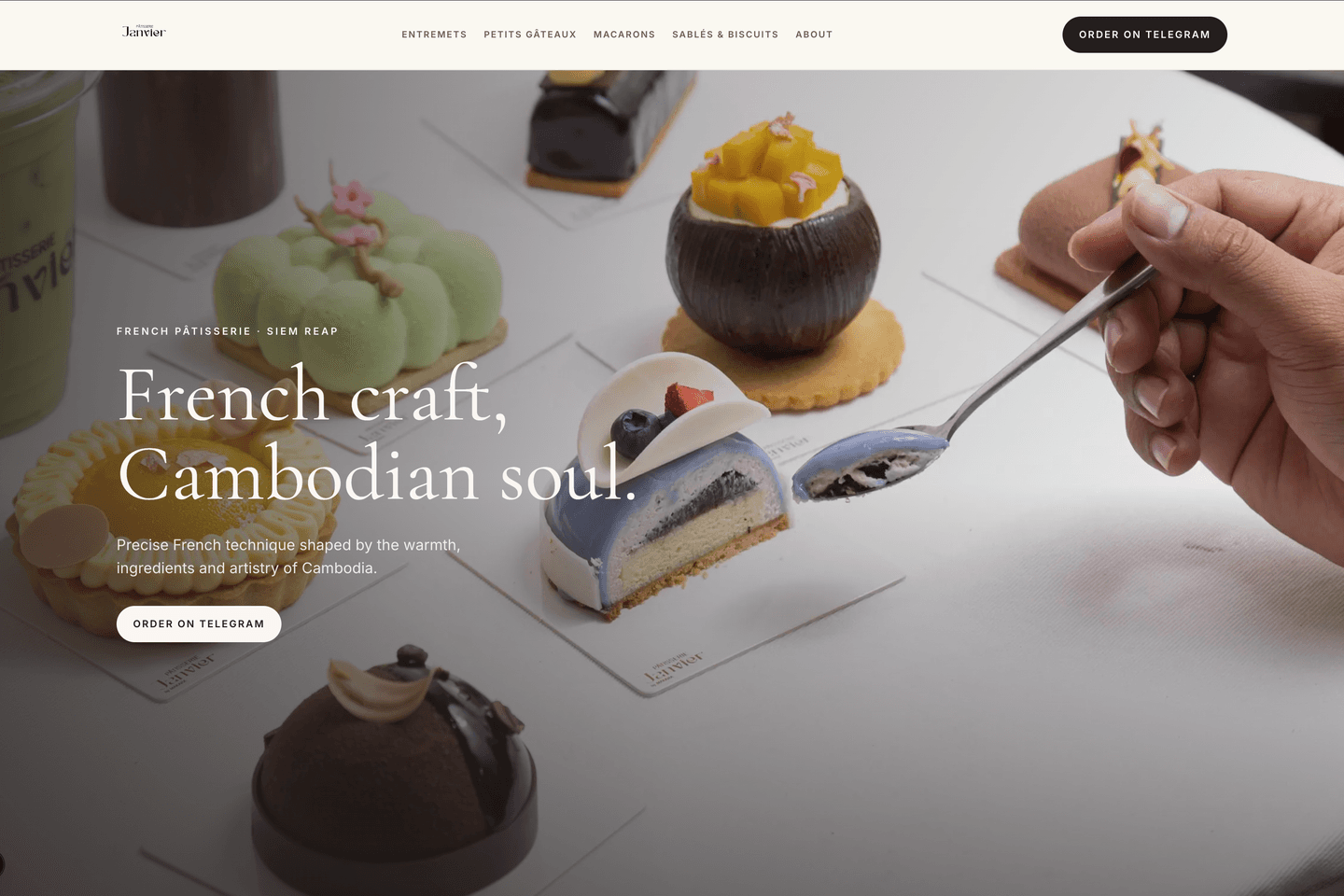 Janvier Pâtisserie homepage hero showing an assortment of French pastries on a table